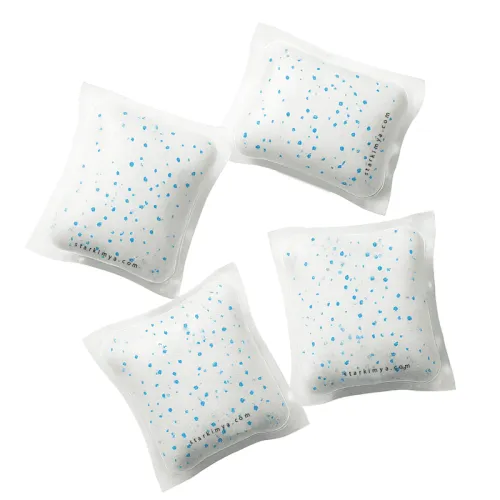 Water-soluble laundry detergent pods with white powder and blue speckles in transparent PVA film